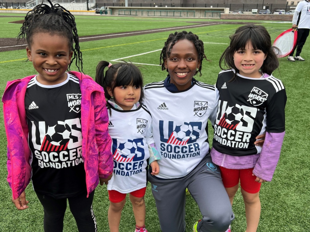 Woman coach with three girls smiling